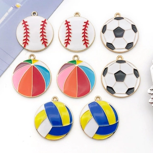 Flat lay of colorful enamel sports ball pendants including baseball and soccer for DIY crafts
