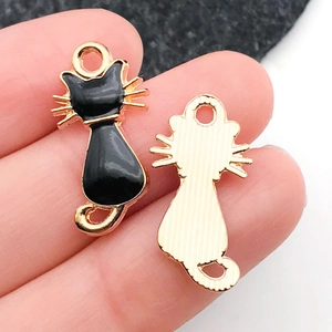 Detalle de un colgante de gato de esmalte negro con reverso dorado para joyería artesanal