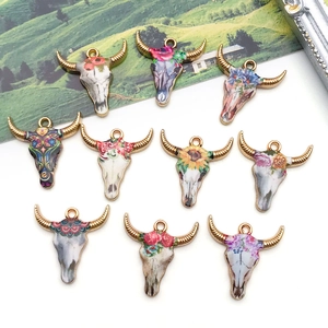 Detailed macro view of bohemian style bull skull alloy pendants with floral enamel patterns