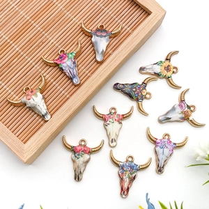 Close-up of enamel bull skull charms with bohemian floral patterns for jewelry making