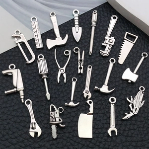 Détail macro de breloques outils en argent vintage pour la création de bijoux DIY