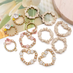 Flat lay of alloy floral pendants with enamel flowers and pearls for DIY jewelry making