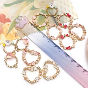 Close-up of DIY alloy enamel pendants featuring pearls, flowers and hearts for jewelry making