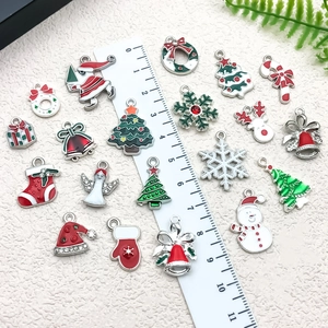 Détail de breloques de Noël en émail montrant les dimensions avec une règle blanche