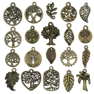 Macro detail of 20 bronze tree of life pendants with hollow engraving and family inscriptions