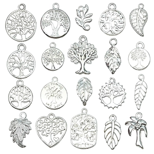 Detailed close-up of 20 silver-colored tree of life and leaf charms for DIY jewelry making