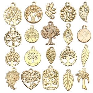 Flat lay of 19-piece golden Tree of Life and leaf alloy pendants for DIY jewelry making