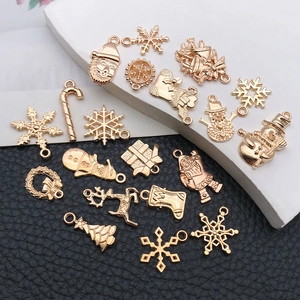 Gros plan de breloques de Noël en or rose avec des motifs de flocons et de rennes