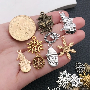 Detailed close-up of vintage Christmas alloy charms with coin for size reference