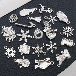 Detailed macro view of silver Christmas charms including snowflakes and reindeer for DIY jewelry