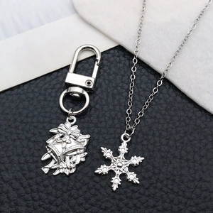 Detailed close-up of silver Christmas bell keychain and snowflake pendant jewelry charms