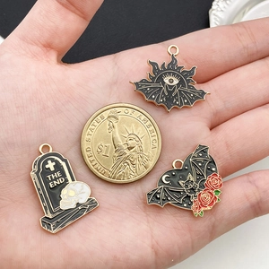 Gothic Halloween Ohrringe mit Geist, Fledermaus und Rose neben einer Münze zum Größenvergleich