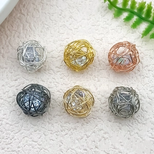 Macro shot of six metallic hollow wire woven pendants with zircons for DIY jewelry making