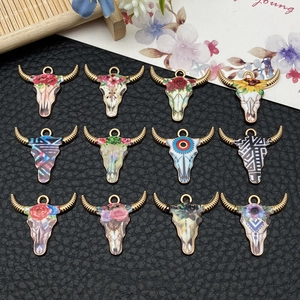 Flat lay of 12 detailed cow skull pendants with floral patterns for DIY jewelry making