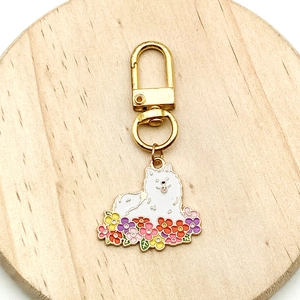 Vue détaillée du pendentif chien blanc en alliage avec breloques fleurs en émail