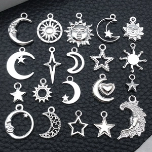 Makro-Detail von silbernen Sonnen-, Mond- und Sternanhängern für DIY-Schmuckherstellung