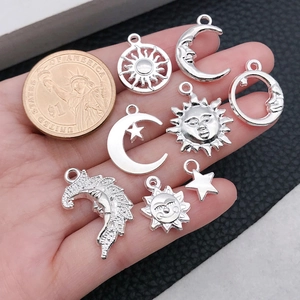 Silberne Sonnen- und Mond-Anhänger für DIY-Schmuck, mit Münze zum Größenvergleich abgebildet
