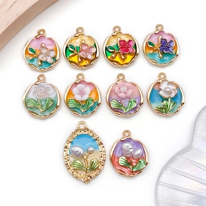 Detailed macro view of ten assorted floral and pearl alloy charms for DIY jewelry making