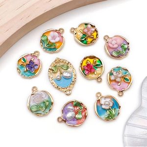 Detailed view of assorted enamel flower and fruit pendants with faux pearls and alloy base