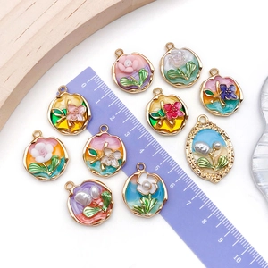 Macro detail of assorted enamel flower pendants with pearls for DIY jewelry making