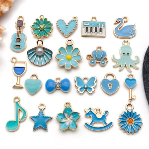 Flat lay of 20 assorted blue enamel gold alloy charms for DIY jewelry making