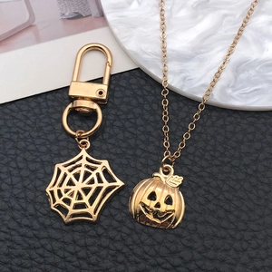 Detail of gold spider web keychain and pumpkin pendant for DIY Halloween jewelry
