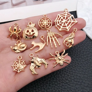 Golden Halloween DIY charm set featuring spider, pumpkin, and ghost metal pendants