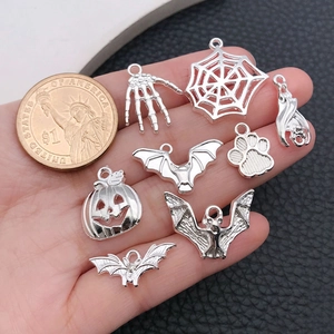 Macro-opname van zilveren Halloween-bedeltjes met spinnen, vleermuizen en een muntje