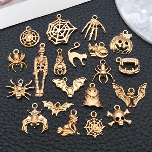 Detail of 19 assorted gold-plated Halloween charms featuring skulls, ghosts, and pumpkins