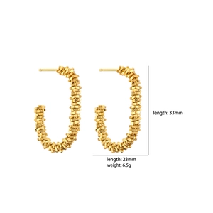 Détail de boucles d'oreilles ovales dorées avec dimensions et texture tissée élégante