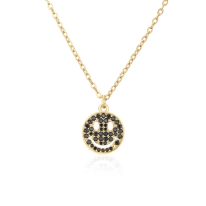 Vista detallada de un collar de cobre dorado con un colgante de smiley de circonitas negras