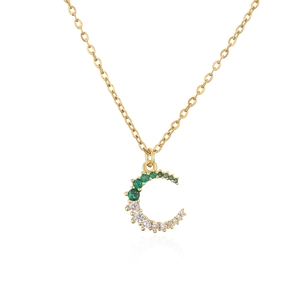 Primer plano de un collar dorado con colgante de luna y piedras de circonita finas