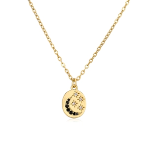 Detalle de un collar dorado con colgante de moneda con motivos de luna y estrellas