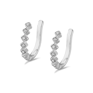 Macro shot of silver ear cuffs with square cubic zirconia stones and polished finish