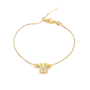 Macro shot of 14K gold M letter bracelet featuring micro-paved cubic zirconia and box chain