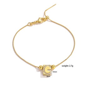 Detail view of gold letter G pendant with micro-pave cubic zirconia on box chain