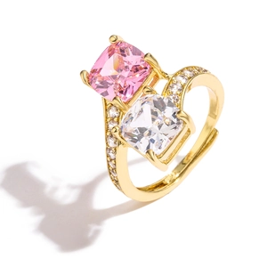 Detail van verstelbare gouden ring met roze en witte vierkant geslepen zirkonia steentjes
