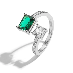 Detail van verstelbare ring met groene smaragd geslepen steen en heldere zirkoon