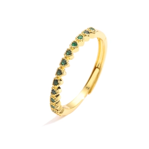 Detail van verstelbare gouden ring met een rij sprankelende groene zirkonia stenen