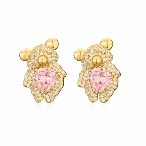 Boucles d'oreilles ours dorées avec zircon et gemme cœur rose sur fond blanc