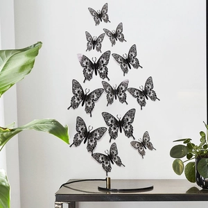 Detailed view of black hollow 3D butterfly wall stickers on a clean white wall