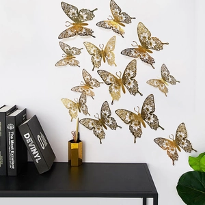 Detail view of 3D hollow gold butterfly wall stickers with intricate floral patterns
