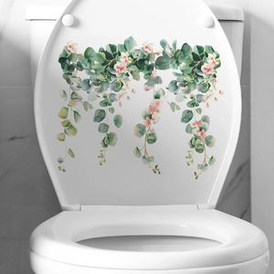 Detail of watercolor tropical green leaves and pink flowers sticker on a white toilet lid