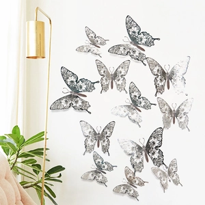 Detailed view of 3D hollow butterfly wall stickers with silver metallic finish on a white wall