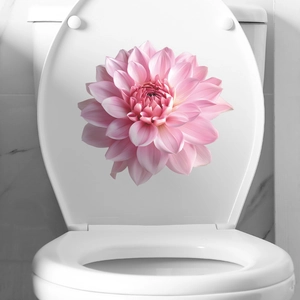 Detailed view of pink dahlia flower sticker on a white toilet lid in a clean bathroom