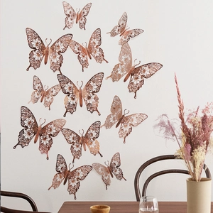 Detailed view of 3D hollow butterfly wall stickers in rose gold finish on white wall