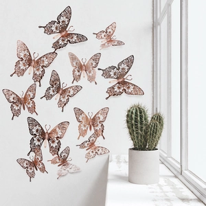Detailed macro view of 3D rose gold hollow butterfly wall decals with floral patterns