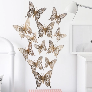 Detailed arrangement of gold hollow-out 3D butterfly wall stickers on a clean white wall