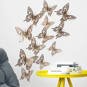 Detailed view of 3D rose gold hollow butterfly wall stickers on a minimalist white wall