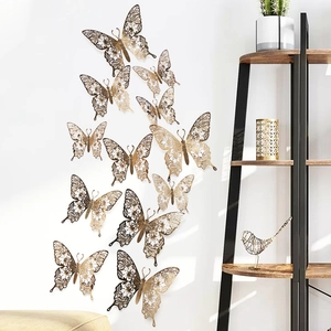 Detailed view of 3D gold hollow butterfly wall stickers on a clean white interior wall